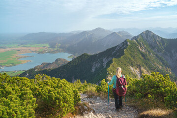 Eine Wanderin auf dem Gratweg zwischen Heimgarten und Herzogstand blickt auf den Walchensee und den Jochberg