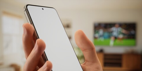 Caucasian male watching football at home with friends, making bets on his phone