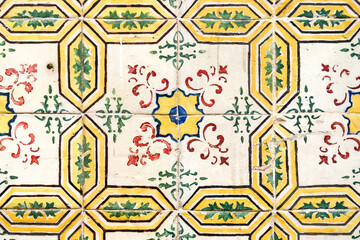 Antique tile with yellow, green, red and blue motifs on a white background (Lisbon)