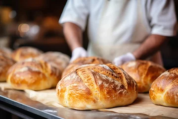 Keuken spatwand met foto Talented baker kneading dough in bakery   blurred background with copy space, bright photo © Ilja