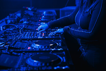 Close up view of a female dj with fresh nails mixing at a music festival - obrazy, fototapety, plakaty