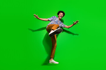 Fototapeta na wymiar Full length photo of good mood cool man dressed print shirt dancing having fun isolated green color background