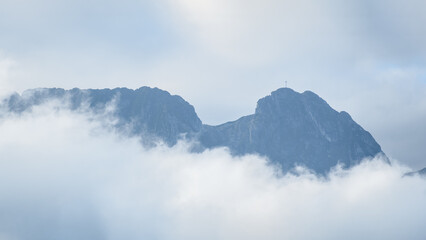 Polish Tatra Mountains, Giewont peak - sleeping knight, foggy morning, thick fog obscures the mountain peaks hidden in the shadow.
