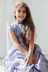 Naklejka premium Beautiful curly girl 7 children in purple dress