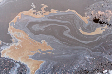 Obraz premium A marble texture of a rainbow spill of gasoline on a sidewalk in a puddle as a background