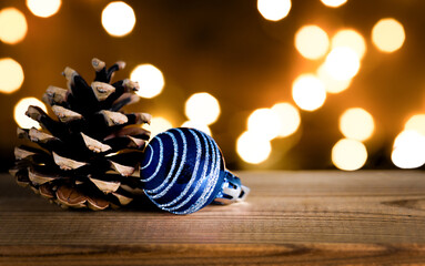 The pine cone and Christmas bauble on wood background.
