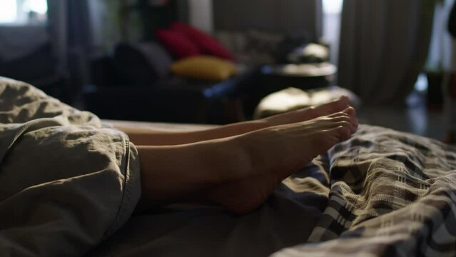 Woman stretching feet while resting in bed