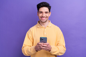 Photo of cheerful positive guy wear yellow polo communicating instagram twitter telegram facebook isolated violet color background