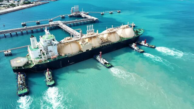 LNG (Liquified Natural Gas) tanker anchored in Gas terminal gas tanks for storage. Oil Crude Gas Tanker Ship. LPG at Tanker Bay Petroleum Chemical or Methane freighter export import	
