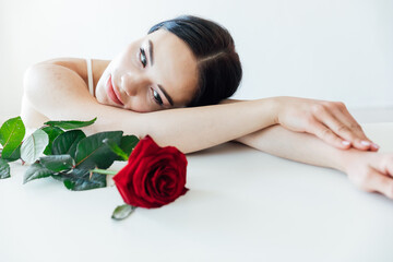 Obraz na płótnie Canvas beautiful brunette woman with red rose flower