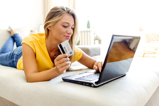 Shot of a young woman using a laptop and credit card at home.