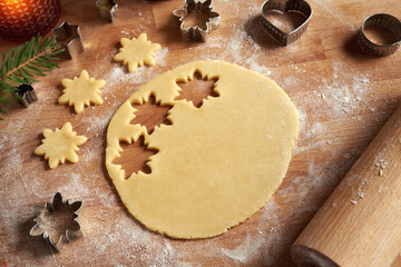 Pastry dough with cut out star shapes - preparation of Linzer Christmas cookies