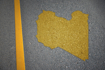 yellow map of libya country on asphalt road near yellow line.