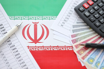 Iranian business calculations on table with iranian money and pen close up