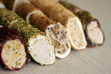 Rolls of turkish delight with many different flavors and fillings close up on table of vendors market bazaar with copy space