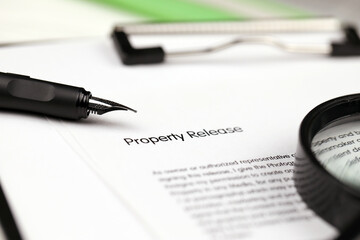 Property Release on A4 tablet lies on office table with pen and magnifying glass close up - obrazy, fototapety, plakaty