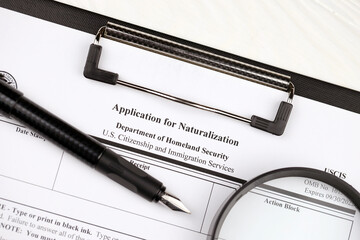 N-400 Application for Naturalization blank form on A4 tablet lies on office table with pen and...