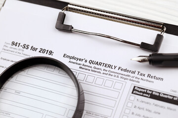 IRS Form 941-SS Employer's quarterly federal tax return blank on A4 tablet lies on office table...