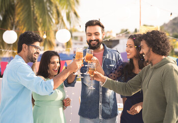 Group of friends at party champagnes glasses at party during new year evening party gathering - concept of millennial lifestyle, birthday celebration and enjoyment - obrazy, fototapety, plakaty