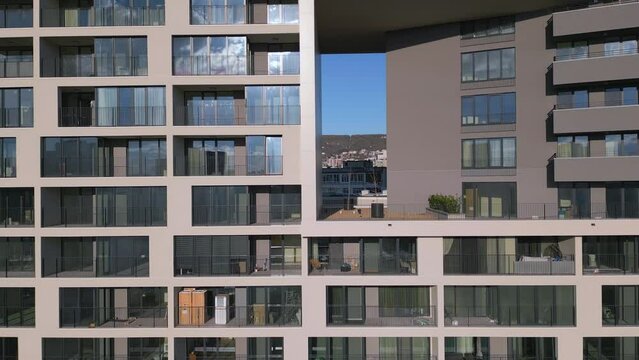 Drone flight along the facade of a modern office or residential building background