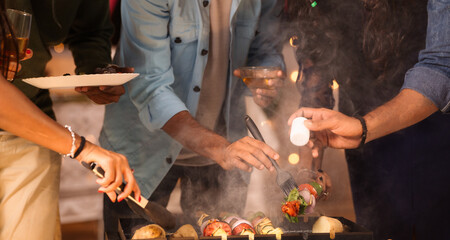 Close up shot, Group of friends hands busy cooking barbecue grills for dinner at 2024 new year...