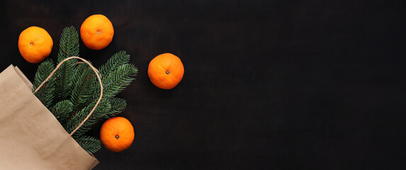 A spruce branch in a craft bag, ripe tangerines, a top view of the items on the table. Christmas...