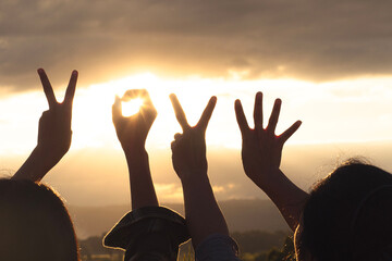 hands raised up against beautiful sunrise, number 2024.,Hands with New Year 2024 symbols,