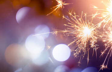 sparkling from fireworks and light bokeh. background for New Year's celebrations, banner design. on the dark blue night sky