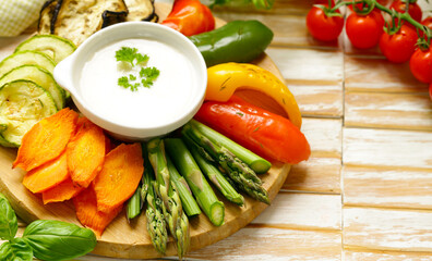 vegetables with yoghurt dip on wooden board