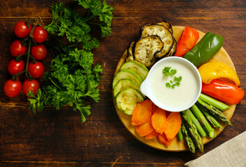 vegetables with yoghurt dip on wooden board
