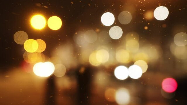 Christmas cheer in a city or town and falling snow. Night cityscape in wintertime on the eve of the Christmas holidays. Blurred city view and snowfall as background