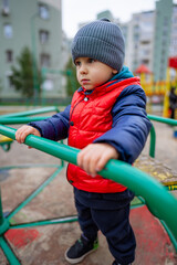 Fototapeta na wymiar A little boy in a red jacket and a gray hat. A Little Boy in a Red Jacket and a Gray Hat