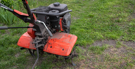 Work on a home farm in the spring. Plowing the field with a cultivator before planting seeds and...
