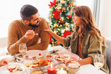 Couple having Christmas dinner with friends at home