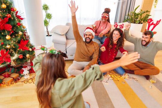 Friends playing charades while celebrating Christmas at home