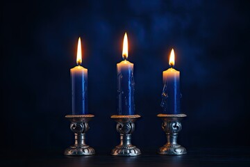 Candlesticks with burning candles on dark blue background