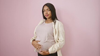 Expecting young woman touching her belly relaxed over isolated pink background - an emotional, casual expression of impending motherhood - Powered by Adobe