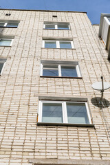 Lots of windows in the house. Rectangular, white. Brick white wall.