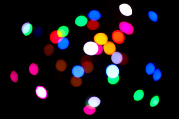 Defocused colorful lights on black background. Bokeh effect.