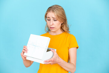 Portrait of sad displeased woman opening gift package