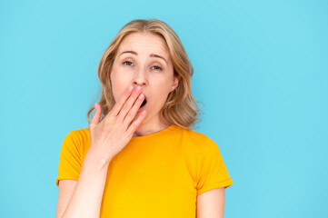 Young woman feeling bored, yawn and covering open mouth with hand - obrazy, fototapety, plakaty