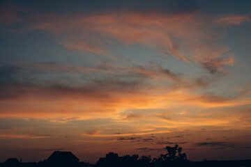 An image of a beautiful and unusual sunset. The ever-changing sky. An inspiring observation of clouds and the surrounding natural world. Can be used as banner background, wallpaper.