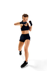 Dynamic full length portrait of sportsman, female boxer, exuding strength and confidence, against clean white studio background.