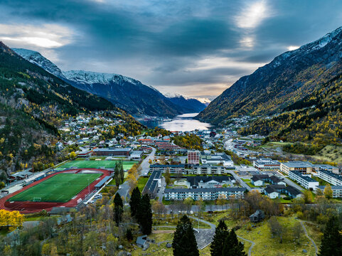 aerial view over town of odda on fjord with mountains covered with snow on background in norway