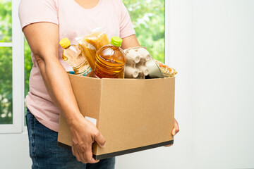 Volunteers putting various dry food in donation box for help people.