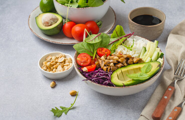 Vegan concept. Vegetables, mushrooms, avocados, nuts and rice in a buddha bowl. Complete vegan lunch. horizontal, on a light background, free space for text..