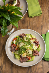Delicious salad with meat, egg, tomato and arugula