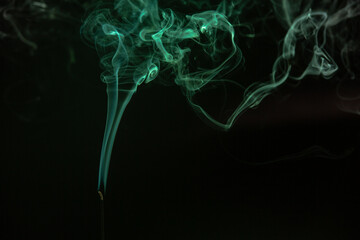 Green smoke lingering on black background