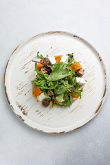 Delicious salad with feta cheese, arugula and pumpkin