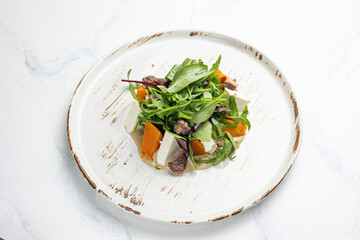 Delicious salad with feta cheese, arugula and pumpkin